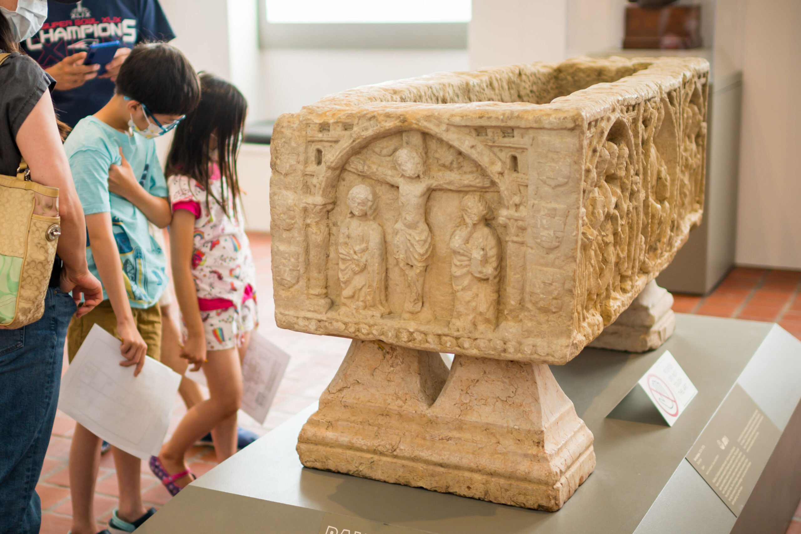 Young guests viewing a medieval sarcophagus