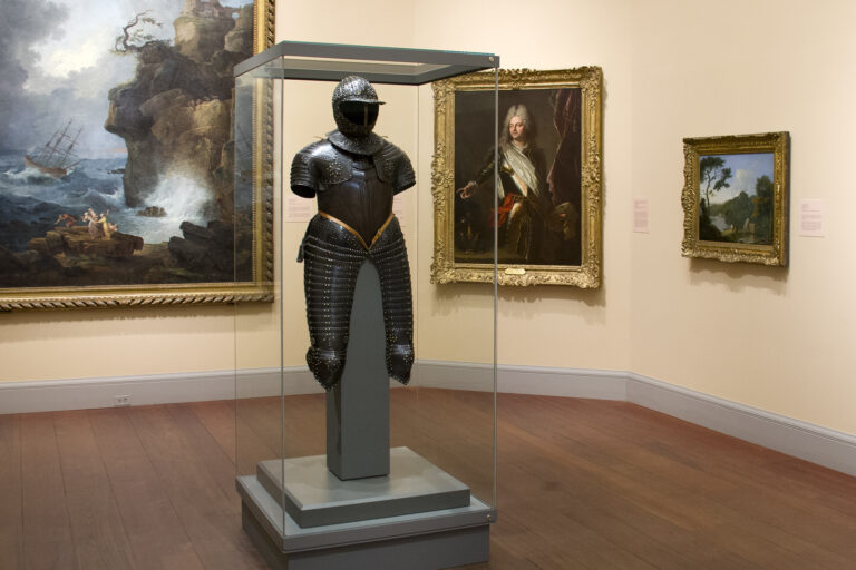A suit of armor on display in a European art gallery