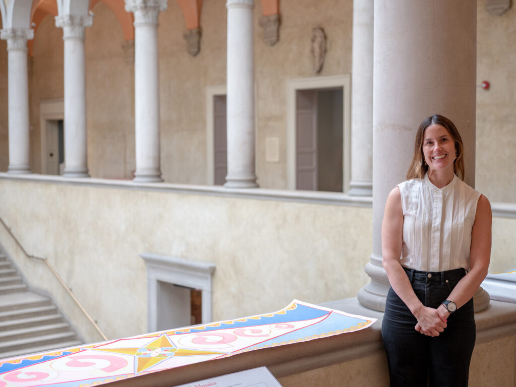 Artist Crystalle Lacouture stand next to concept painting for Wall at WAM