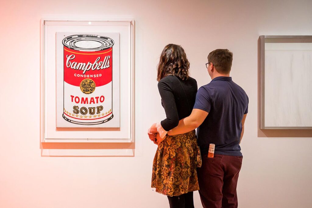 A couple viewing 'Campbell's Soup Can (Tomato)' by Andy Warhol