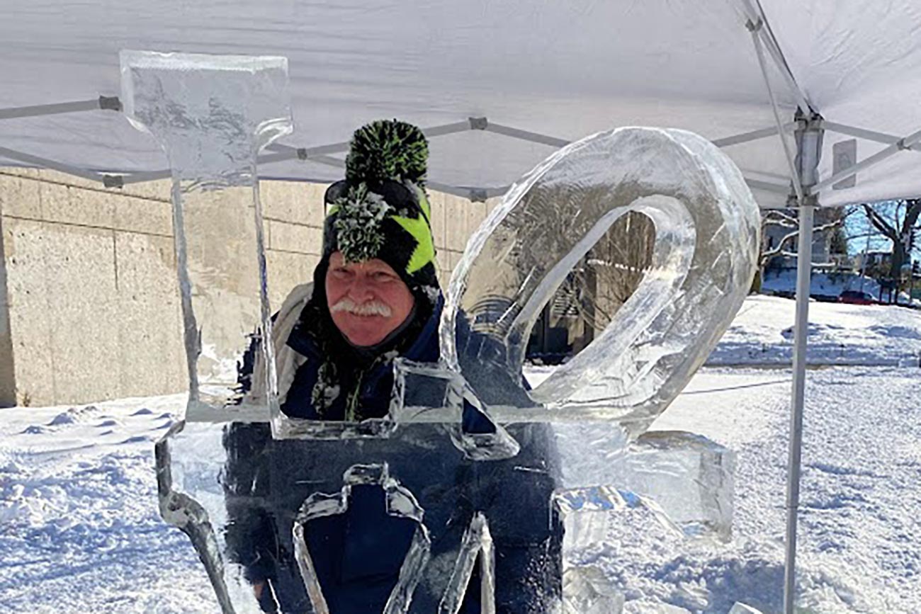 Chuck Koser poses with one of his ice sculptures