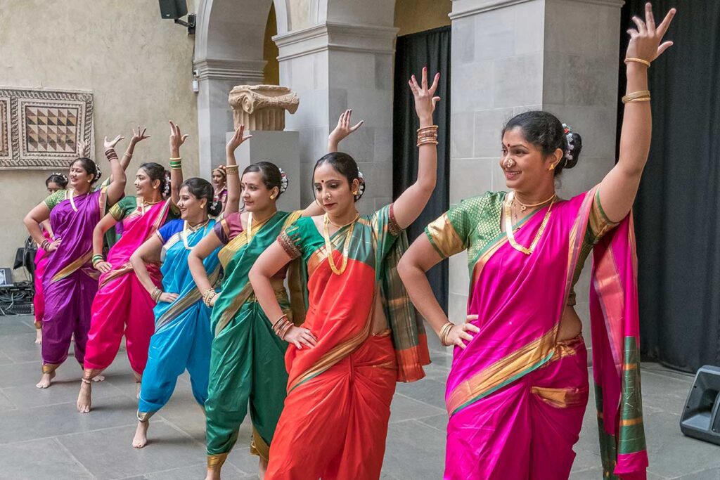 A colorful line of dancers performing during a Diwali celebration at WAM