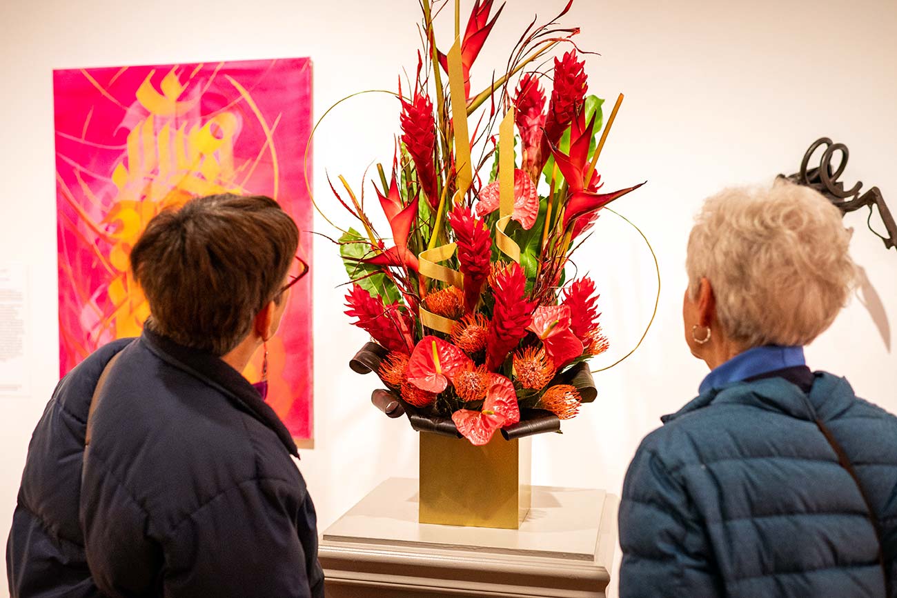 A floral interpretation is studied from both sides by two visitors