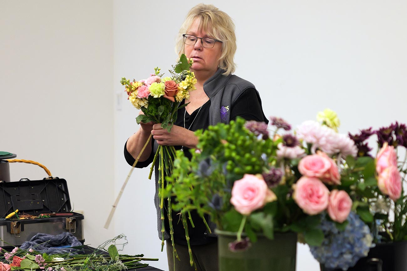 A floral designer working on a flower arrangement